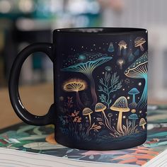 a black coffee mug sitting on top of a table next to a pile of books