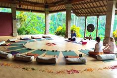 people sitting on yoga mats in an open room