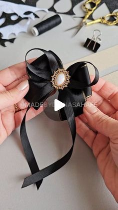 someone is holding a black bow with pearls on it