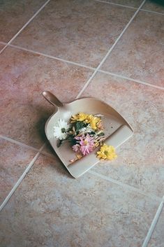 a plate with some flowers on it sitting on the floor next to a bowl and spoon