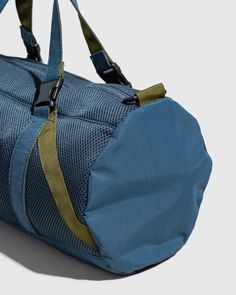 a blue duffel bag sitting on top of a white floor