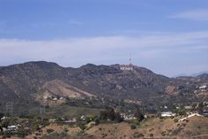 the mountains are covered with trees and houses in the foreground is a radio tower on top of a hill