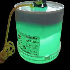 a green light and lantern in a white bucket with a yellow cord attached to it