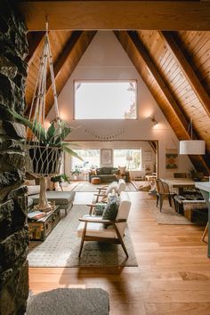 a living room filled with lots of furniture and a tall wooden ceiling mounted to the side of a wall