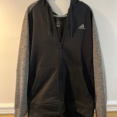 Mens Zip Up Hoodie With Large Front Pockets And Hood. In Perfect Condition No Stains, Piling, Or Fading. Never Worn. Color: Black And Grey Size: Large If You Need Specific Measurements Please Comment Below! All Orders Ship Next Business Day And Are Carefully Packaged! Smoke Free And Pet Free Home! Your Order Will Be Carefully Packaged And Shipped Out Quickly To Ensure You Receive Your New Favorite Piece In No Time. Black Athleisure Fleece Jacket For Winter, Sporty Black Fleece Jacket With Drawstring Hood, Adidas Casual Track Jacket For Gym, Gray Sporty Hooded Jacket For Cold Weather, Black Sporty Fleece Jacket Hoodie, Black Hooded Jacket For Sports Season Outdoor Activities, Gray Sporty Hooded Jacket With Fleece Lining, Black Fleece Hoodie Jacket In Athleisure Style, Sporty Gray Hooded Jacket For Cold Weather