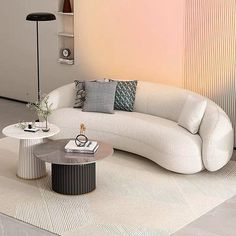 a white couch sitting on top of a rug next to a table and lamp in a living room