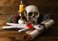 a skull sitting on top of a wooden table next to some candles and other decorations