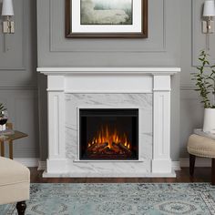 a living room with a fire place in the center and a painting on the wall