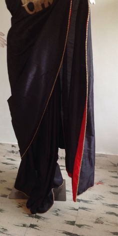 "Stylish black semi silk saree with intricate elephant hand embroidery and raw silk unstiched blouse in red with matching elephant embroidery at the sleeves. This is a unique one of a kind piece and the zardosi work is truly beautiful. Saree length 5.5 meters Blouse fabric 1 meter 44\" wide Saree is custom made and ships out in 2 weeks time.Shipping time is 4-5 days with tracking. We also offer blouse and petticoat stitching for saree as additional services. Please convo me if you need help or h Black Cotton Silk Pre-draped Saree For Diwali, Traditional Cotton Silk Pre-draped Saree With Embroidered Border, Traditional Pre-draped Cotton Silk Saree With Embroidered Border, Elegant Embroidered Black Pre-draped Saree, Elegant Black Embroidered Pre-draped Saree, Black Silk Saree With Resham Embroidery, Black Silk Pre-draped Saree With Resham Embroidery, Black Cotton Silk Pre-draped Saree With Zari Work, Elegant Cotton Silk Blouse Piece With Embroidered Border