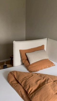 an unmade bed with two pillows on it