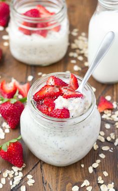 a jar filled with oatmeal and strawberries on top of a wooden table