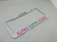 a license plate frame with the word hawaii on it in pink, green and blue beads