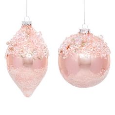 two pink christmas ornaments hanging from strings