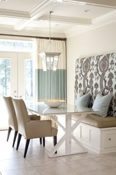 a dining room table with six chairs and a bench in front of the glass door