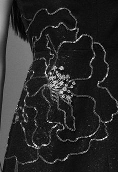 the back of a woman's dress with sequins and flowers on it