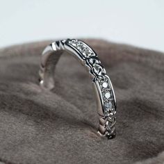 a close up view of a wedding ring on a cushioned surface, with diamonds in the middle