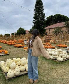 a woman standing in front of a display of pumpkins