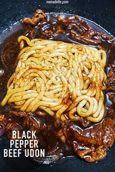 black pepper beef udon is being cooked in a skillet with the words, black pepper beef udon