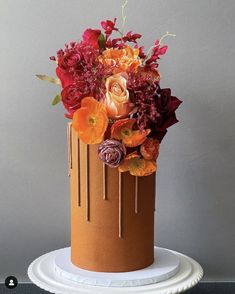 a cake decorated with flowers and dripping icing