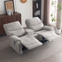 the reclining chair has two seats and is in front of a book shelf with books on it