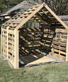 a wooden structure made out of pallets in the grass