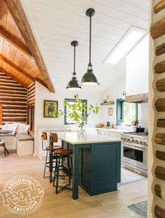 an open kitchen and dining room area with wooden beams on the ceiling, white counter tops, and green island