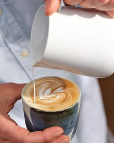 a person is pouring milk into a cup