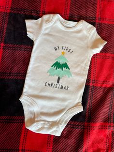 Minimal and simple baby's first Christmas onsie. Holiday White Cotton Onesie, White Cotton Onesie For Holidays, Cute Christmas Holiday Onesie, Cute Christmas Cotton Onesie, Cute Cotton Christmas Onesie, Cute Christmas Onesie, Cute Cotton Onesie For Holidays, Christmas Onsies, Baby Christmas Onesie