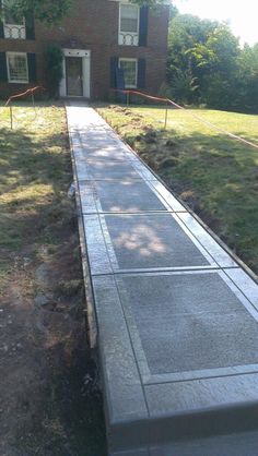 a cement walkway in front of a brick building