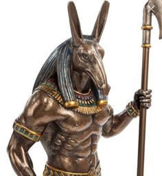 anub statue holding a hammer and wearing egyptian garb, isolated against a white background