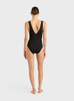 The Victoria One Piece in black is one of best sellers as it is extremely flattering and comfortable to wear. Made from a single layer of our Italian engineered Singuleur fabric® that uses an advanced flexion technology to envelope the body like a second skin. The deep plunge V neckline front and back sits above a wide band that provides support under the bust whilst contouring and flattering the waistline. Comfortable wide shoulder straps move with the body and stay safe in the water. A timeles Black Swimwear With Seamless Construction, Black Second-skin Swimwear With Seamless Construction, Black Swimwear With Seamless Construction And Second-skin Fit, Black Functional Stretch Swimwear, Functional Black Stretch Swimwear, Compressive Seamless Black Swimwear, Black Polyamide Swimwear For Sports, Black Swimwear With Moderate Back Coverage And 4-way Stretch, Black 4-way Stretch Swimwear For Yoga