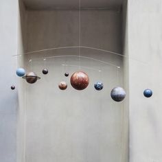 the solar system is hanging in front of a white wall with no people around it