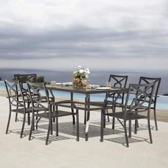 a table and chairs on the beach with an ocean in the background