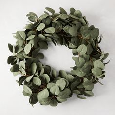 a wreath made out of eucalyptus leaves on a white background with copy - space in the middle