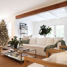 a living room filled with furniture and a christmas tree in the middle of the room