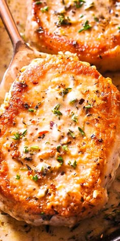 two pork chops with cheese and herbs in a skillet, ready to be eaten