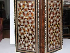 an intricately designed wooden screen on display in a living room or dining room area