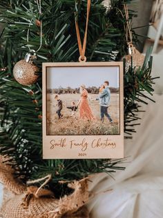 an ornament hanging from a christmas tree with a family photo on the front