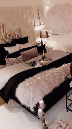 a bedroom decorated in black and white with lights on the headboard, bedding, and pillows