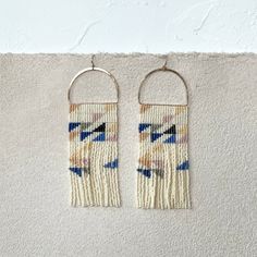 two earrings hanging on the wall next to each other