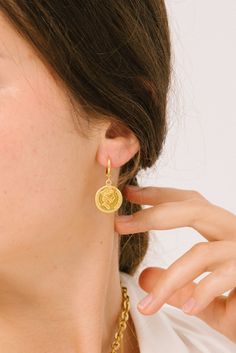 This super chic earring has a vintage look and feel that will take you back to old world Europe. The Gianna Earring features a small coin, whose design is inspired by the Baroque period. The coin is attached to a small hoop so that you can enjoy a dangling earring that will highlight your face and add just the right amount of shine and glow. While the Gianna is designed with the past in mind, it still fits in well with the modern world of fashion and will look good with any outfit. At Koko Carpi Baroque Period, Coin Earrings, Chic Earrings, Baroque Fashion, World Of Fashion, Vintage Looks, Period, 18k Gold, Dangle Earrings