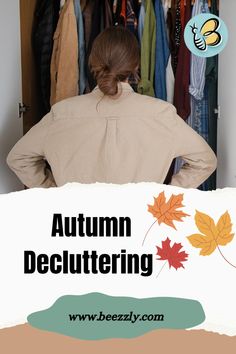 a woman standing in front of an open closet with autumn clothing on hangers behind her