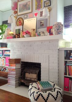 a living room with a fire place and pictures on the wall above it's mantle