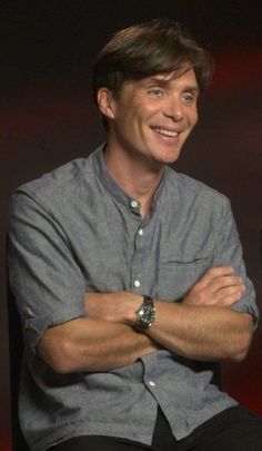 a smiling man with his arms crossed