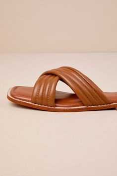 The Rag & Co Eura Tan Leather Slide Sandals will make you more than ready for sunshine and plenty of compliments! Smooth genuine leather shapes these chic sandals that feature a trendy square-toe bed and wide, crisscrossing vamp straps that boast a quilted-like effect. The simple slide-on design makes getting dressed easy and effortlessly cute! Available in whole sizes only. 0. 5" rubber heel. Cushioned insole. Rubber sole has nonskid markings. Genuine leather upper. Balance man made materials. Chic Cross Strap Sandals For Vacation, Leather Sandals With Padded Heel And Cross Strap, Brown Beach Sandals With Padded Heel, Brown Padded Heel Sandals For Beach, Chic Brown Cross Strap Sandals, Beach Sandals With Square Toe, Leather Sandals With Square Toe For Vacation, Trendy Brown Sandals With Square Toe, Trendy Brown Square Toe Sandals