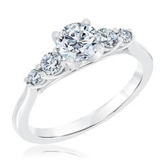 a three stone engagement ring with four stones on the side and an accent diamond in the center