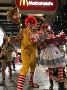 two people dressed up as clowns at a mcdonald's