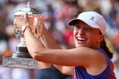 a female tennis player holding up a trophy