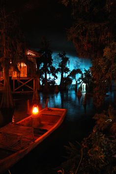 a boat is sitting on the water at night with a lit candle in front of it