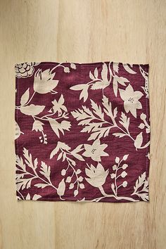 a red and white flowered napkin on top of a wooden table